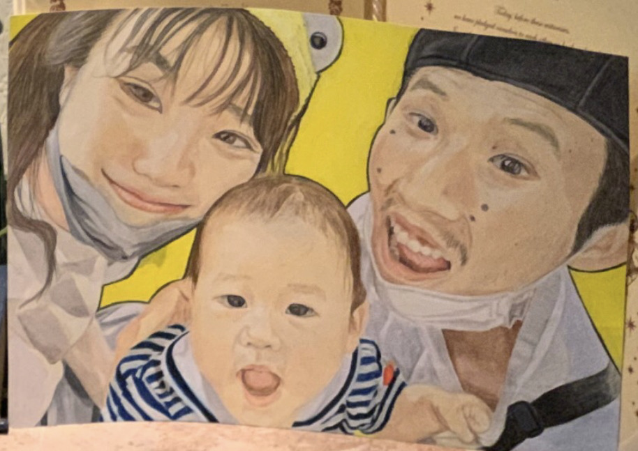 赤ちゃんを囲む三人家族の色鉛筆画