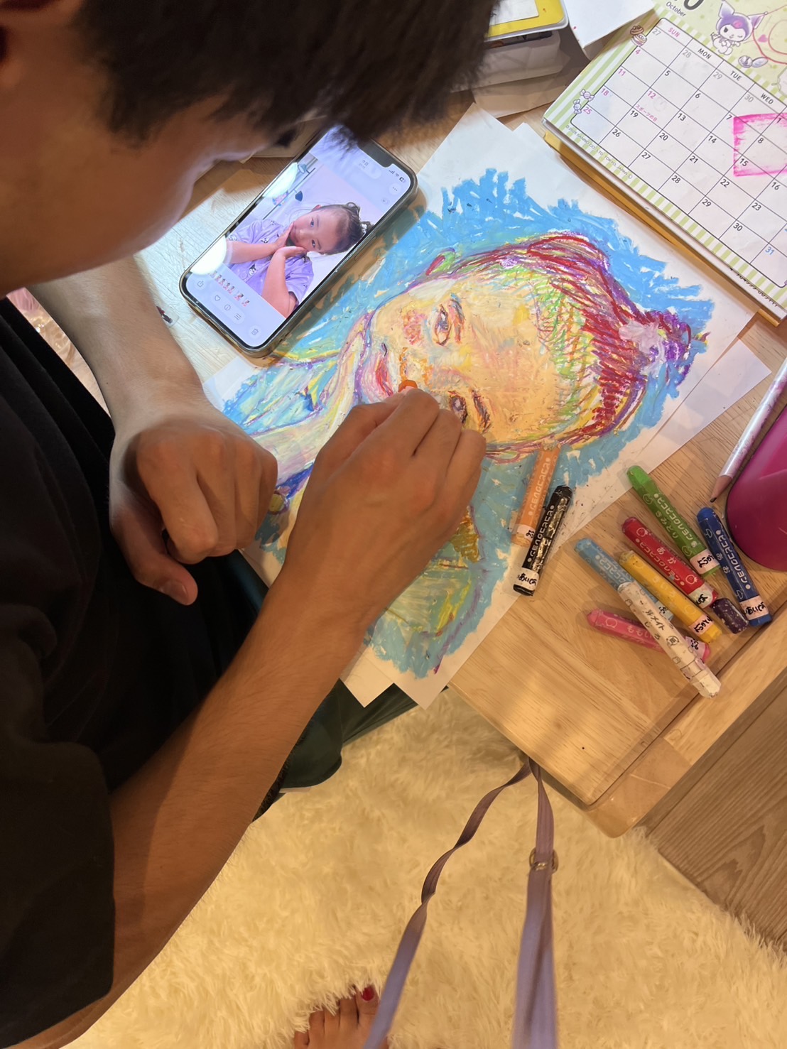 写真を見ながら、パステルで肖像を描く新門岳大