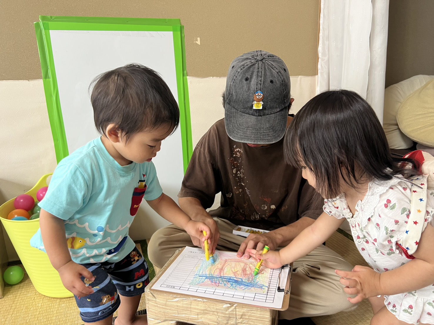 子どもたちと一緒に色を重ねる新門岳大